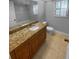 Bathroom with a wood vanity, granite countertops, tile floors, and shower with glass doors at 3184 Wessex Way, Clearwater, FL 33761
