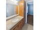 Bathroom with granite countertop vanity, wood cabinets, and doorway to bedroom at 3184 Wessex Way, Clearwater, FL 33761