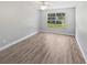 Bright bedroom with large window, ceiling fan, and stylish wood-look flooring offers a cozy and inviting space at 3184 Wessex Way, Clearwater, FL 33761