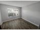Bright bedroom with large window, ceiling fan, and stylish wood-look flooring offers a cozy and inviting space at 3184 Wessex Way, Clearwater, FL 33761