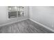 A bright, empty bedroom features a window and modern gray vinyl plank flooring at 3184 Wessex Way, Clearwater, FL 33761