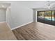 Open concept living room features wood floors and a sliding door to the lanai and pool at 3184 Wessex Way, Clearwater, FL 33761