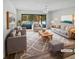 Beautifully staged living room with neutral tones, stylish furniture, and a view of the sparkling pool through sliding glass doors at 3184 Wessex Way, Clearwater, FL 33761