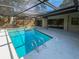 A refreshing swimming pool enclosed with a screen enclosure, surrounded by a spacious deck, perfect for relaxation at 3184 Wessex Way, Clearwater, FL 33761