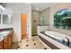 Elegant bathroom featuring a soaking tub, walk-in shower, and granite finishes at 2513 Andrea Lynn Dr, Lutz, FL 33549