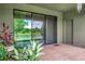 Covered patio with brick flooring and sliding glass doors, overlooking a pond at 6722 Wild Elm Ct, Wesley Chapel, FL 33545