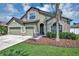 Two-story house with three-car garage, stone accents and palm trees at 6722 Wild Elm Ct, Wesley Chapel, FL 33545