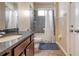 Small bathroom with granite countertop, tub shower combo, and dark wood cabinets at 6722 Wild Elm Ct, Wesley Chapel, FL 33545