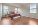 Bedroom with wood flooring, a bed, and two windows at 6722 Wild Elm Ct, Wesley Chapel, FL 33545