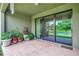 Covered patio with brick flooring and sliding glass doors, overlooking a pond at 6722 Wild Elm Ct, Wesley Chapel, FL 33545