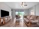 Spacious living room featuring a sofa, chair, and glass coffee table with view to backyard at 6722 Wild Elm Ct, Wesley Chapel, FL 33545