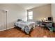Bedroom with wood flooring, a bed, and a workspace at 6722 Wild Elm Ct, Wesley Chapel, FL 33545