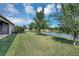 Backyard with pond view, lush green grass, and mature trees at 6722 Wild Elm Ct, Wesley Chapel, FL 33545