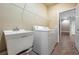 Laundry room with washer, dryer, utility sink, and overhead shelving at 6722 Wild Elm Ct, Wesley Chapel, FL 33545