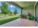 Covered patio with brick flooring and potted plants, overlooking a pond at 6722 Wild Elm Ct, Wesley Chapel, FL 33545