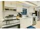 Modern kitchen with stainless steel range, white cabinets, and updated countertops at 14147 81St Ave, Seminole, FL 33776