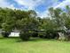 Lush greenery surrounds this home, which features an attached garage, a well-maintained lawn, and mature trees at 3240 San Mateo St, Clearwater, FL 33759
