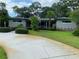 Well-maintained front yard featuring mature trees, manicured hedges, and a spacious driveway leading to the home at 3240 San Mateo St, Clearwater, FL 33759