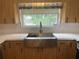 An upgraded kitchen features a stainless steel farmhouse sink, modern faucet, and light wood cabinets at 3240 San Mateo St, Clearwater, FL 33759