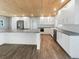 Modern kitchen with white cabinets, large island, and wood ceiling at 1019 Deer Run, Venice, FL 34293