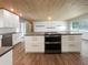 Modern kitchen with white shaker cabinets and concrete island at 1019 Deer Run, Venice, FL 34293