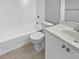 Bathroom with white tile, tub and shower combo, toilet, and vanity with speckled countertop at 9308 San Bernandino Ave, Englewood, FL 34224
