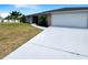 Exterior of home with white driveway, stone accents, palm trees, and well-kept lawn at 9308 San Bernandino Ave, Englewood, FL 34224