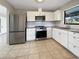 Kitchen boasts stainless steel appliances, white subway tile backsplash, and tiled floor at 9308 San Bernandino Ave, Englewood, FL 34224