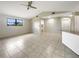 Bright living room with high ceilings, a ceiling fan, and tiled flooring throughout at 9308 San Bernandino Ave, Englewood, FL 34224