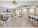 Bright living room with high ceilings, a ceiling fan, and tiled flooring throughout at 9308 San Bernandino Ave, Englewood, FL 34224