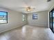Bright main bedroom featuring tile flooring, large windows, and a ceiling fan at 9308 San Bernandino Ave, Englewood, FL 34224