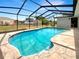 Backyard pool featuring a screened enclosure, stone pavers, and view of the yard at 9308 San Bernandino Ave, Englewood, FL 34224