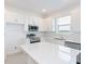 Bright kitchen featuring white cabinets and a large quartz island at 17339 Peregrine Way, Punta Gorda, FL 33982