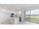 Modern kitchen with white cabinets, island, and sliding glass doors at 17339 Peregrine Way, Punta Gorda, FL 33982
