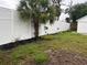 Landscaped backyard with a white vinyl fence and palm trees at 1620 Lakeview Pl, Englewood, FL 34223