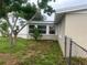 Side view of the house with a sunroom addition and grassy yard at 1620 Lakeview Pl, Englewood, FL 34223