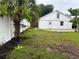 Backyard with a white fence, grass, and a palm tree at 1620 Lakeview Pl, Englewood, FL 34223
