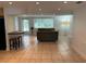 Living room with tiled floors, a couch, and access to kitchen area at 1620 Lakeview Pl, Englewood, FL 34223