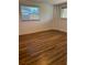 Bright bedroom featuring wood-look flooring and a window with blinds at 1620 Lakeview Pl, Englewood, FL 34223
