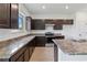 Kitchen with dark cabinets, granite countertops, and stainless steel appliances at 9034 Sandy Bluffs Cir, Parrish, FL 34219