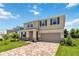 Two-story house with a neutral color scheme, landscaping, and a brick paver driveway at 9034 Sandy Bluffs Cir, Parrish, FL 34219