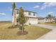 Two-story house with light beige siding, teal accents, and a paver driveway at 101 Runaway Field Ave, Nokomis, FL 34275