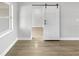 Open hallway with barn door and hardwood floors at 4104 W Gray St, Tampa, FL 33609