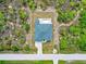 Aerial view of a new house with a pool, driveway and lush landscaping at 9573 Shelburne Cir, Port Charlotte, FL 33981