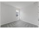 This bedroom features neutral carpeting, a window, white walls, and a door at 9584 Vibrant Lane, Venice, FL 34292