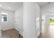 A clean laundry room with tile floors, utility sink, shelving, and a door leading to the backyard at 9584 Vibrant Lane, Venice, FL 34292