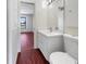 A clean bathroom featuring a white vanity, a well-lit mirror, and a classic toilet, offering a functional space at 7087 Spinnaker Blvd, Englewood, FL 34224