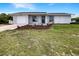 Charming single-story home with a well-maintained lawn, landscaped flower beds, and an attached single car garage at 7087 Spinnaker Blvd, Englewood, FL 34224