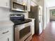 Efficient kitchen featuring stainless steel appliances, white cabinetry, and a compact design for a functional cooking space at 7087 Spinnaker Blvd, Englewood, FL 34224