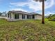 Exterior view of the rear of a well maintained home with a spacious backyard and patio at 3524 Cessna St, Port Charlotte, FL 33948
